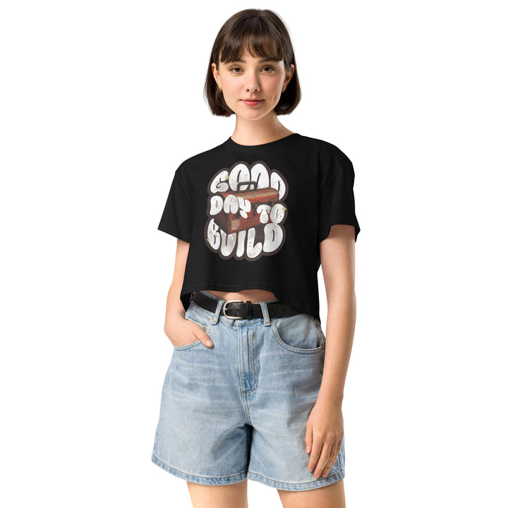 Woman wearing the black Good Day to Build crop tee with denim shorts